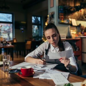a chef looking at paperwork and using a calculator