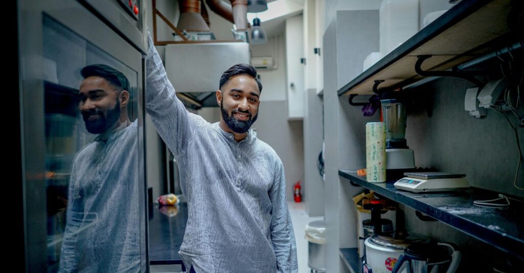 a man standing next to a commercial oven