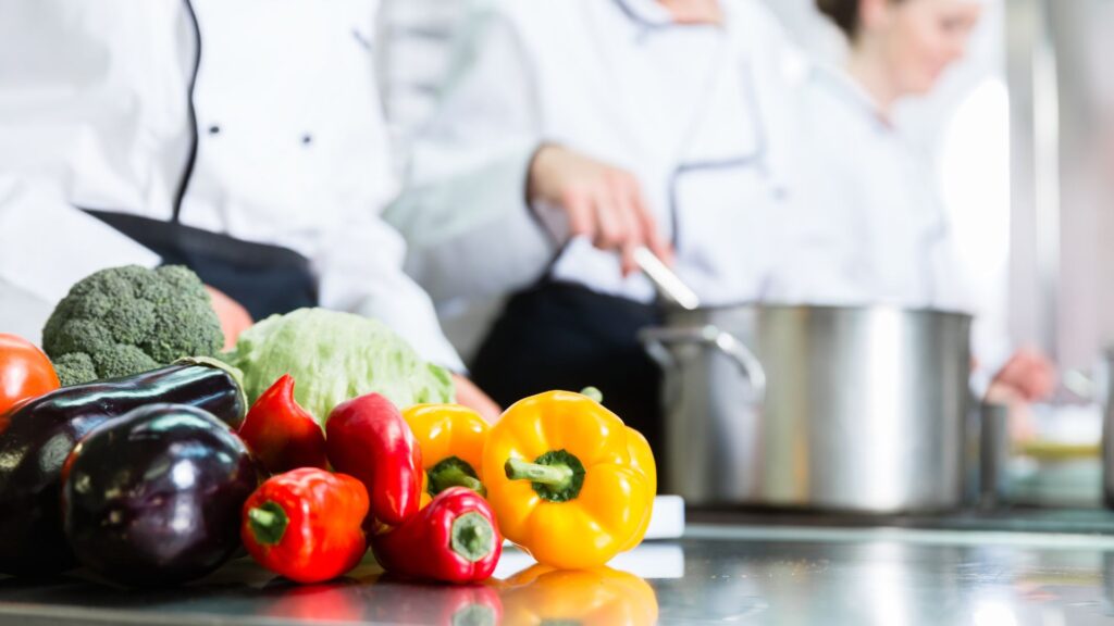chef in background behind veggies