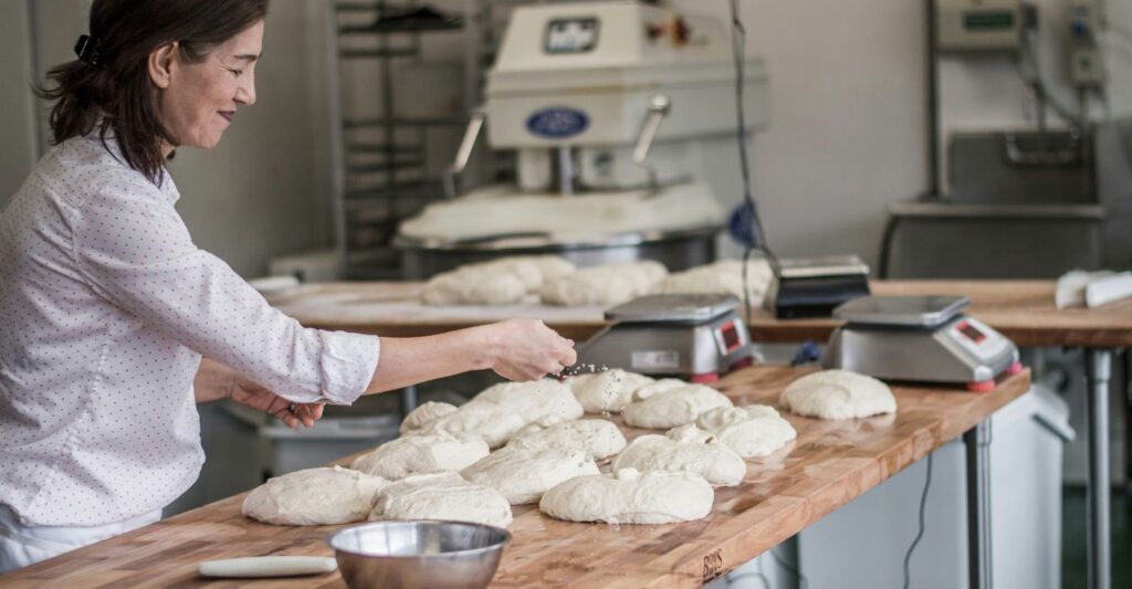 a woman making large batches of bread